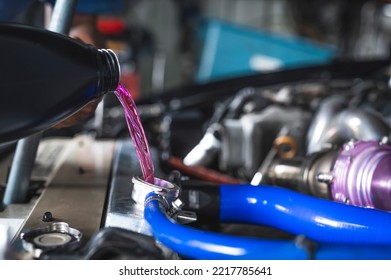 Auto Mechanic Filling Pre-mixed Long Life Coolant Fluid In To Aluminum Radiators.