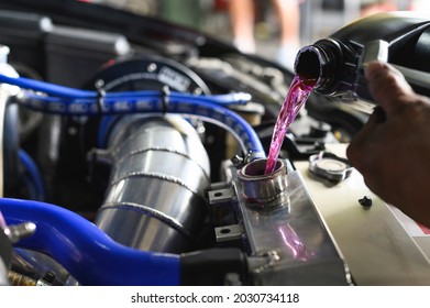 Auto Mechanic Filling Pre-mixed Super Long Life Coolant Fluid In Aluminum Car Radiator Fill Hole.
