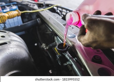 Auto mechanic filling super long life coolant pre-mixed fluid into the car radiator fill hole. - Powered by Shutterstock