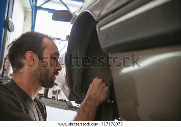 Auto Mechanic Fixing\
Car In A Workshop
