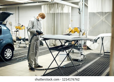 Auto mechanic grinds car part for painting. Car body work auto repair paint after accident - Powered by Shutterstock