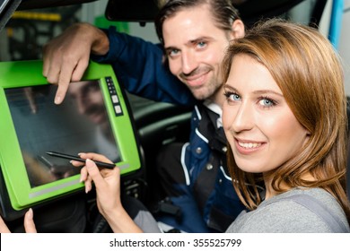 Auto mechanic is guiding an attractive female trainee in checking the car performance with a digital device. Concept for the fact that more and more women participate in jobs previously typical for - Powered by Shutterstock