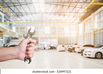 Auto Mechanic Hand Holding Wrench Over Car Repair Service Centre Garage