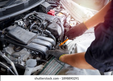 Auto mechanic hand working with engine in garage, car service technician repairing customer car at automobile service center, inspecting car suspension and engine system, vehicle repair service shop. - Powered by Shutterstock