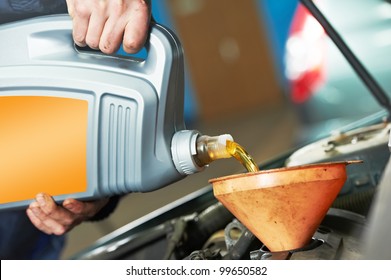 Auto Mechanic Hands Replacing And Pouring Motor Oil Into Automobile Engine At Maintenance Repair Service Station