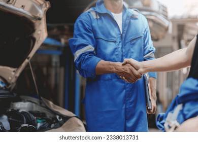 Auto mechanic handshake successful colleague in auto service center To congratulate the success of car maintenance. Professional car mechanic shaking hands. - Powered by Shutterstock