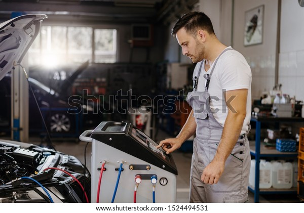 Auto\
mechanic having car diagnostic in a\
workshop
