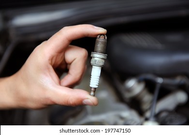 Auto Mechanic Holds An Old Spark Plug