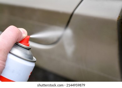 Auto Mechanic Injects Anti-rust Spray To To Protect The Corroded Surface Of The Car. Rust Proof Oil Spray. Selective Focus.