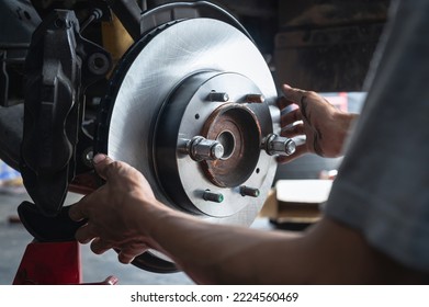 Auto mechanic installing car front brake rotors.	 - Shutterstock ID 2224560469