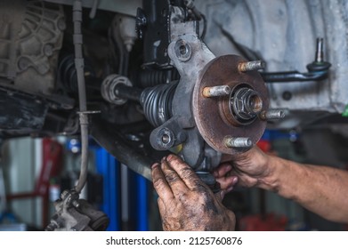 Auto mechanic installing car suspension.