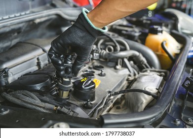 Auto mechanic installing an ignition coil pack.