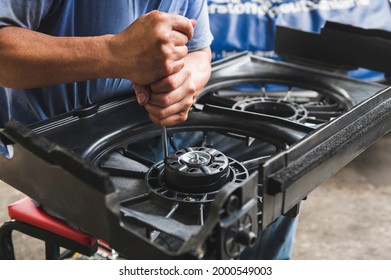 Auto Mechanic Installing A Radiator Cooling Fan Motor Into Radiator Fan Housing.