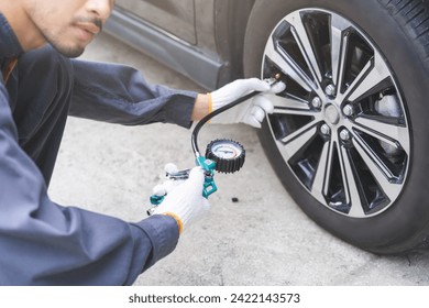 Auto mechanic man checking tire measure air pressure, measurement with gauge for car tyre, mechanic maintenance repair, fix car flat tire with psi pump for safety at vehicle garage, service station - Powered by Shutterstock