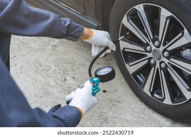 Auto mechanic man checking tire measure air pressure, measurement with gauge for car tyre, mechanic maintenance repair, fix car flat tire with psi pump for safety at vehicle garage, service station - Powered by Shutterstock