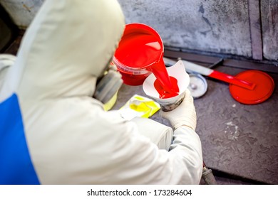 Auto Mechanic Mixing And Pouring Red Paint For Spraying And Painting Cars In Industrial Factory