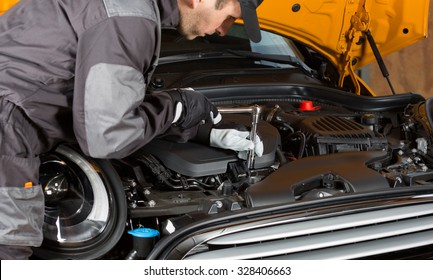 Auto Mechanic performing maintenance on the engine