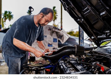 Auto mechanic repair engine Checking a car engine for repair at car garage.Car engine repair. Car service