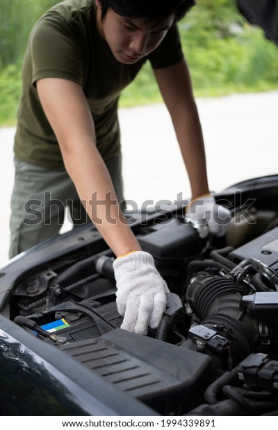 Auto\
mechanic repairing car engine in mechanics\
garage.