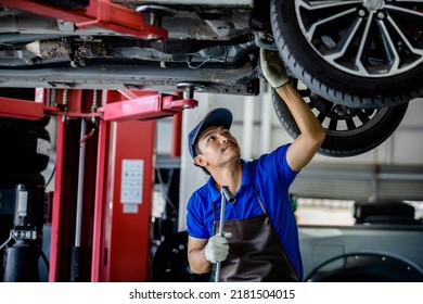 Auto mechanic repairman using a socket wrench working auto suspension repair in the garage, change spare part, check the mileage of the car, checking and maintenance service concept.