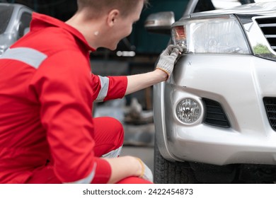 Auto mechanic repairman working on transport body bumper assembly on damaged car at motor repair service station. Technician fixing engine problem vehicle from collision crash accident automotive - Powered by Shutterstock