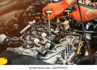 An auto mechanic repairs a car with a socket wrench. Close-up. Quality professional car repair. Content for advertising an auto repair shop, service station, auto store - Powered by Shutterstock