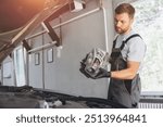 Auto Mechanic Replacing Car Headlight in Modern Repair Shop Garage