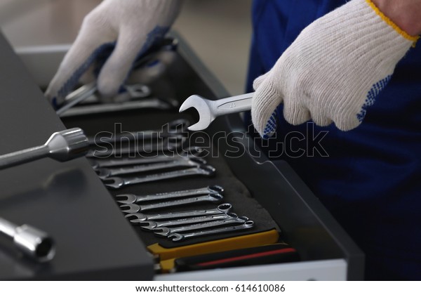 Auto
mechanic selecting tools in car repair shop,
closeup