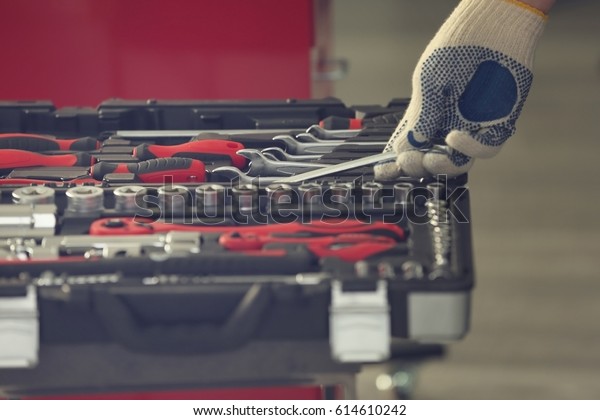 Auto
mechanic selecting tools in car repair shop,
closeup