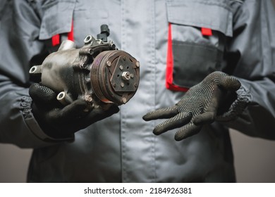 Auto Mechanic Showing A Broken Air Conditioning Compressor Close Up.