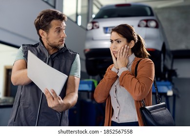 Auto mechanic showing report and car repair costs to shocked woman in a workshop.  - Powered by Shutterstock