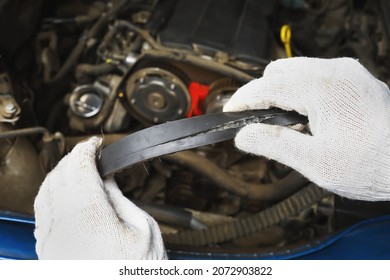 An Auto Mechanic Shows A Timing Belt Burst From The Back Side, Close-up