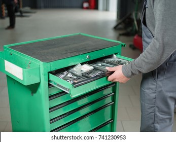 The Auto Mechanic Takes The Tool Tool From The Tool Box. Indoors .