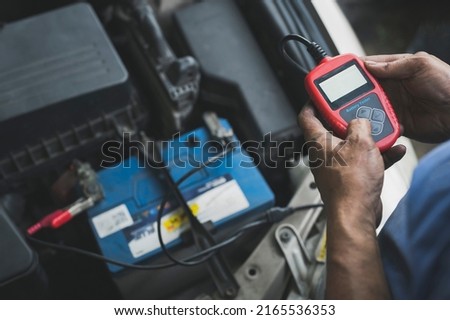 Auto mechanic testing car battery ,car battery tester service.