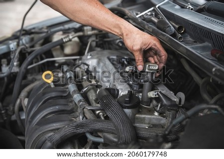 Auto mechanic testing and checking ignition coils. 商業照片 © 