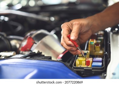 Auto mechanic testing fuses and relays in the  fuse box ,Car Engine Service.