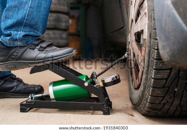 Auto mechanic tightening the\
nuts with a wheel wrench. Seasonal tire change. Car service\
concept
