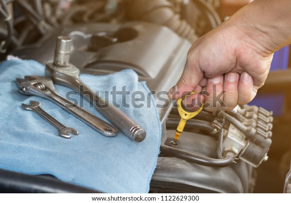 Auto\
mechanic with tool working check and fixed an old car engine at\
service station,change and repair before\
drive\
