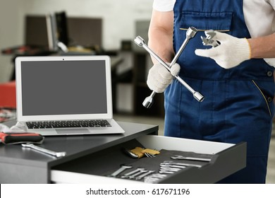 Auto Mechanic With Tools In Car Repair Shop