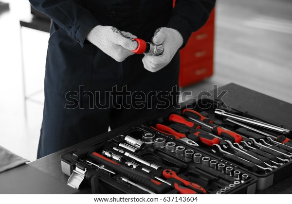 Auto\
mechanic with tools in car repair shop,\
closeup