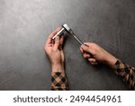 Auto mechanic with torque wrench at grey textured table, top view