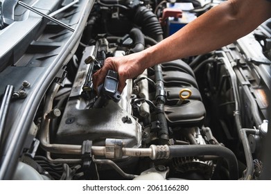 Auto mechanic uninstall and checking an ignition coil pack.