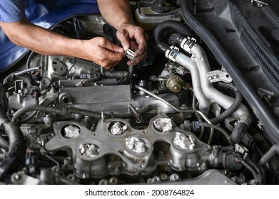 Auto mechanic uninstalling an Ignition Coil 4 Pin Plug Connector.