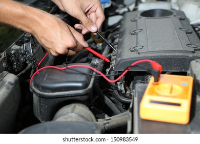 Auto Mechanic Uses Multimeter Voltmeter To Check Voltage Level In Car Battery