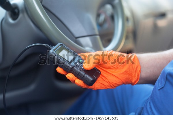 Auto mechanic\
using car diagnostic scan\
tool
