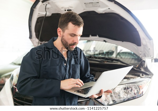 Auto mechanic using computer diagnostic program\
while repairing car in\
workshop