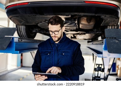 An auto mechanic using tablet in auto mechanic shop. - Powered by Shutterstock