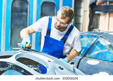 Auto Mechanic Worker Polishing Bumper Car At Automobile Repair And Renew Service Station Shop By Power Buffer Machine