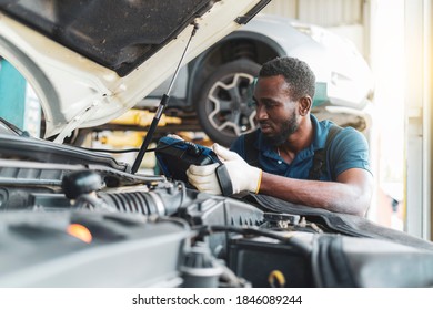 Auto mechanic working in garage, checking the battery ,car repair services concept