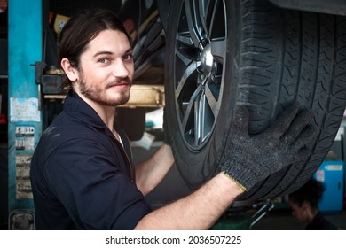 Auto Mechanic Working In Garage, Checking Wheels, Car Service Technician Repair Customer Car At Automobile Service Center, Inspecting Car Under Body And Suspension System, Vehicle Repair Service Shop